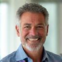 Portrait of David Rodriguez, a confident man in his mid-50s, with a relaxed and approachable demeanor, against a bright, airy background.