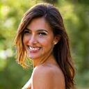 Portrait of Maria Gonzales, a radiant woman in her early 40s, with a genuine smile and healthy, glowing skin, in a soft-focus outdoor setting.